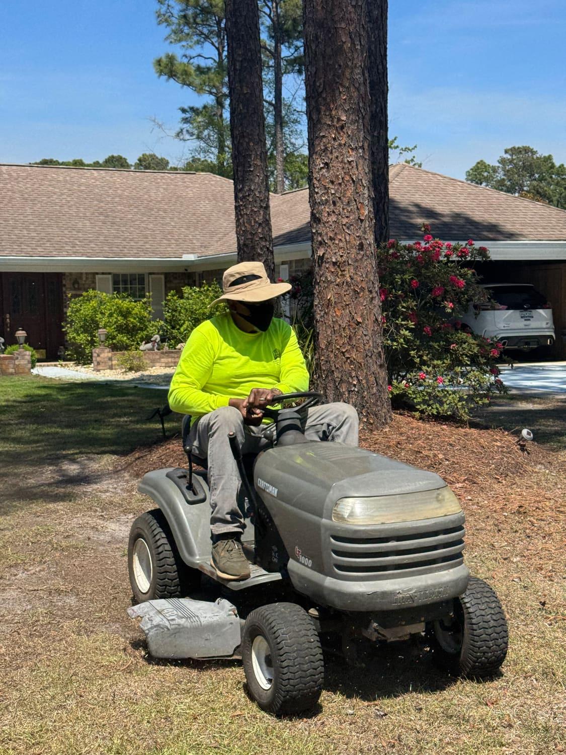 Sam mowing a shaded yard on a riding mower