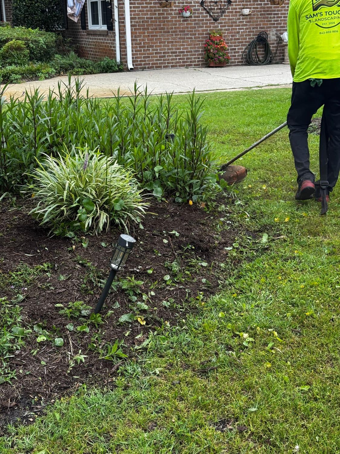Sam's Touch crew edging and refreshing a mulch bed