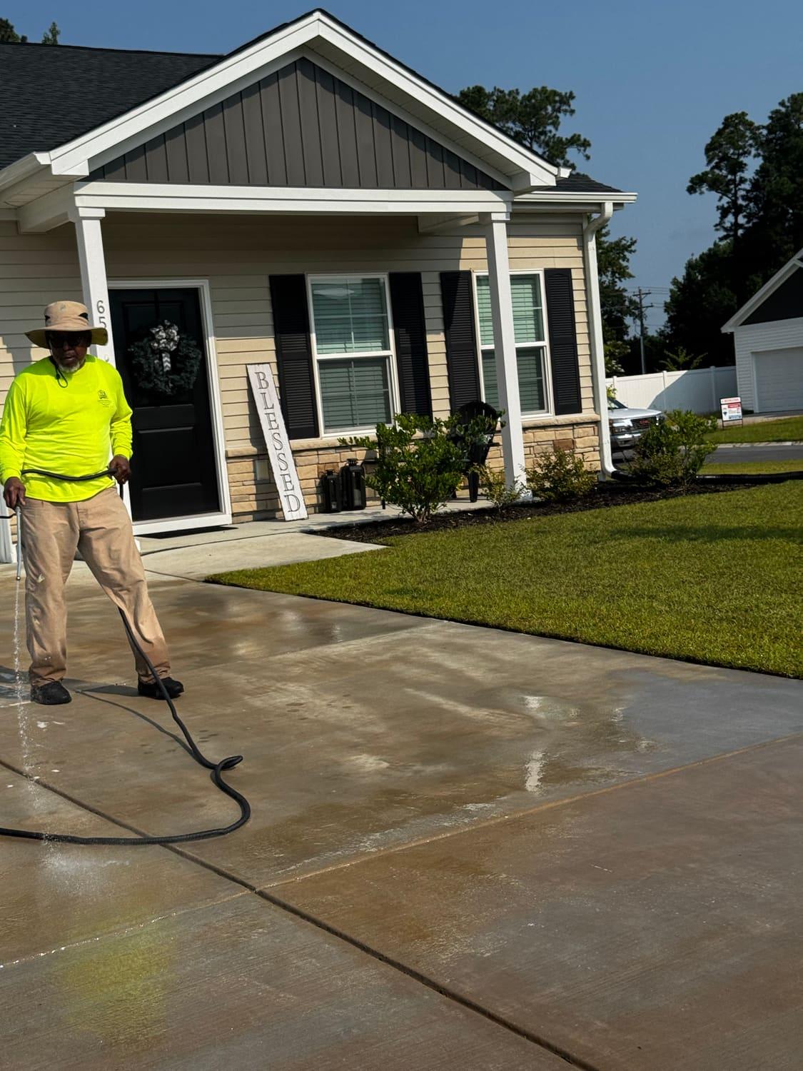 Pressure washing a driveway back to clean